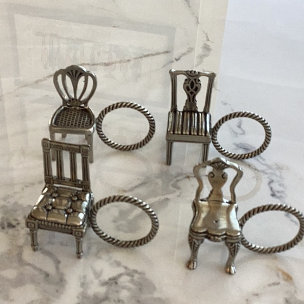 4 pewter napkin rings in the shape of antique chairs.